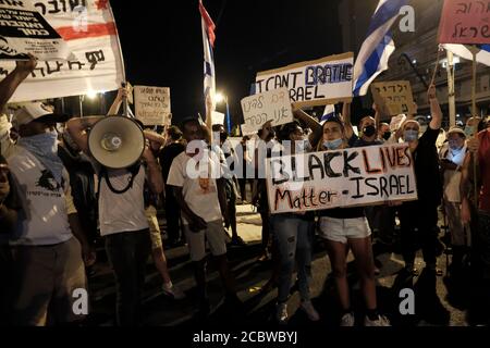 GERUSALEMME, ISRAELE - 15 AGOSTO: Una donna ha un segno 'Black Lives Matter - Israel' come membro della comunità Beta Israel, nota anche come Ebrei etiopi, i nomi degli Ebrei etiopi che sono stati uccisi dalla polizia negli ultimi anni durante una manifestazione di massa cui hanno partecipato oltre 15000 persone come parte della continua Manifestazioni contro il primo ministro Benjamin Netanyahu per la sua accusa di corruzione e la gestione della pandemia di coronavirus al di fuori della residenza ufficiale del primo ministro il 15 agosto 2020 a Gerusalemme, Israele. Foto Stock