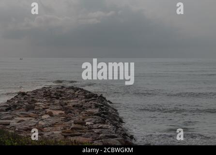 Rocce e mare : Vista delle onde di mare che colpiscono rocce sulla spiaggia calma al mattino. Messa a fuoco e sfocatura. Foto Stock