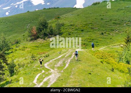 Turisti con zaini escursionistici su sentiero escursionistico che porta da Mestia ai laghi di Koruldi. Un famoso paesaggio a Mestia, Samegrelo-Zemo Svaneti, Georgia. Foto Stock