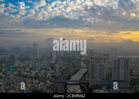 Bella foto aerea di alba colorata e nebbia mattutina nella città di ho Chi Minh con il canale, i ponti del fiume Saigon e gli alti edifici oscuri Foto Stock