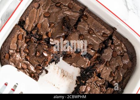 Disposizione piatta. Cottura di brownie fatte in casa con patatine di cioccolato in più sulla parte superiore. Foto Stock