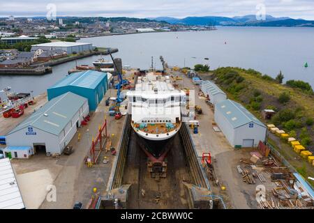 Greenock, Scozia, Regno Unito. 16 agosto 2020. Vista aerea del controverso traghetto CalMac MV Glen Sannox in Dales Dry Dock a Greenock sul fiume Clyde. Il traghetto parzialmente costruito che è ben oltre il budget e gli anni di ritardo, Questa settimana è stato spostato dal cantiere navale Ferguson Marine di Port Glasgow al vicino bacino di arcobaleno per modifiche alla prua, riparazioni e pulizia. Iain Masterton/Alamy Live News Foto Stock