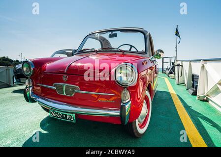 Una classica Autobianchi Bianchina Trasformabile rossa e una Cabriolet Nissan Figaro grigia sul ponte di un traghetto sul Lago di Garda Foto Stock