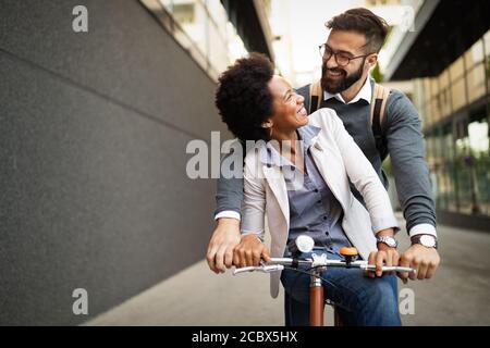 Felice coppia di affari in bicicletta attraverso la città e divertirsi Foto Stock