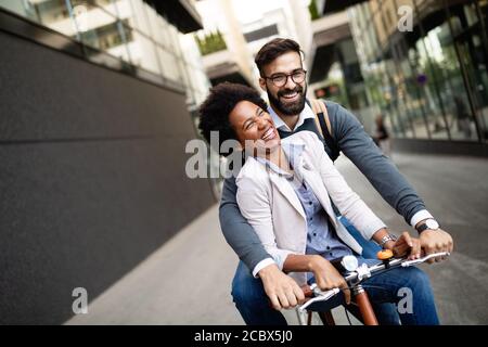 Felice coppia di affari in bicicletta attraverso la città e divertirsi Foto Stock