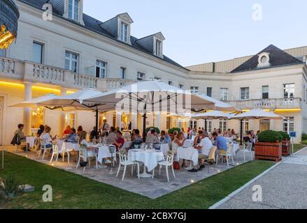 Le persone che mangiano fuori nel ristorante dell'hotel in serata; Chateau Belmont Hotel, Tours Francia; un hotel di lusso nella Valle della Loira Francia Europa Foto Stock