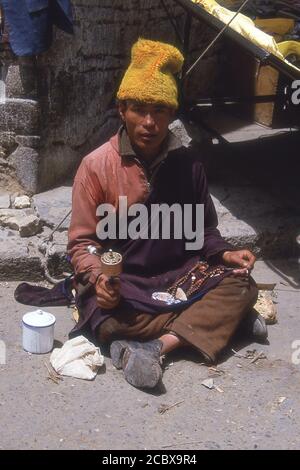 TIBET - PELLEGRINO CON RUOTA DI PREGHIERA FUORI DAL TEMPIO DI JOKHANG, LHASA. Foto Stock