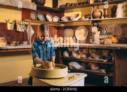 Laboratorio di ceramica. Una bambina fa un vaso di creta. La modellazione di argilla Foto Stock