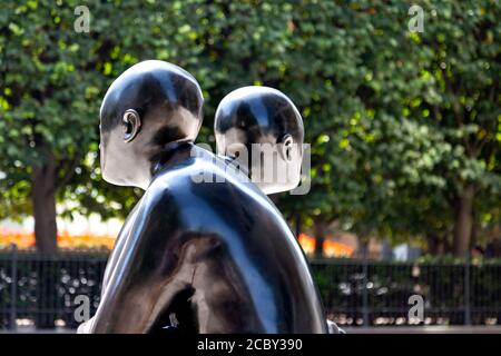 Due uomini su un banco da Giles Penny, scultura in bronzo a Canary Wharf, London, Regno Unito Foto Stock