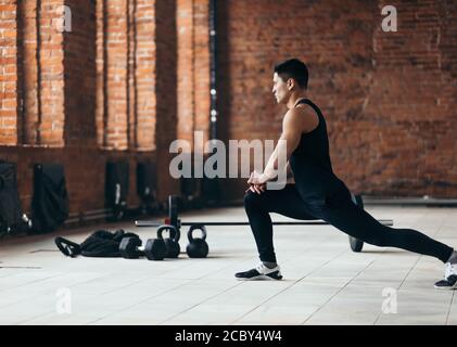 Forte e ambizioso ragazzo asiatico si sta riscaldando prima di allenamento, stile di vita, vita attiva, tempo libero, interesse Foto Stock