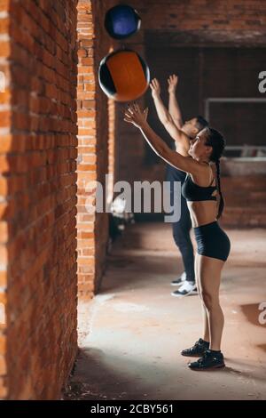 due persone sportive che usano le palle da fitness durante l'allenamento. stile di vita, interesse, foto con vista laterale a tutta lunghezza. Foto Stock