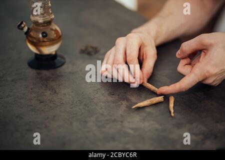 foto ravvicinata dell'uomo che prenderà l'erbaccia di cannabis, marijuana. l'uomo vuole prendere un ronzio, uno stile di vita malsano, droghe, ganja, concetto di medicina della canapa Foto Stock