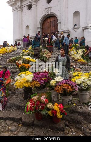 Quiche Maya donne che vendono fiori nel mercato dei fiori sui gradini maya pre-ispanici di fronte alla Chiesa di Santo Tomas a Chichicastenango, Gua Foto Stock