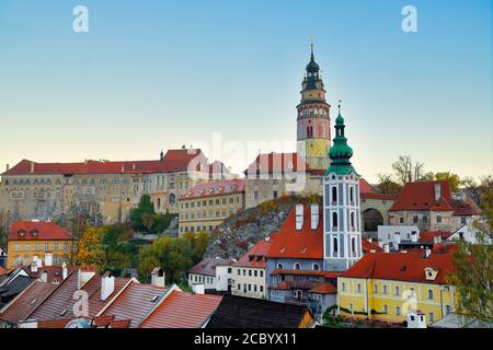 Cesky Krumlov, Repubblica Ceca in autunno, la luce del mattino rende questa città bella. Il tetto della casa rossa con foglie gialle e il fiume i. Foto Stock