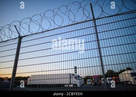 Uhrsleben, Germania. 04 agosto 2020. A causa del loro prezioso carico, i camion sono parcheggiati in un parcheggio di sicurezza circondato da un recinto di filo spinato. (A dpa 'parcheggio camion per la notte - con il crepuscolo viene paura') credito: Klaus-Dietmar Gabbert/dpa-Zentralbild/dpa/Alamy Live News Foto Stock