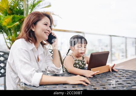 Madre sorridente che chiama al telefono Foto Stock