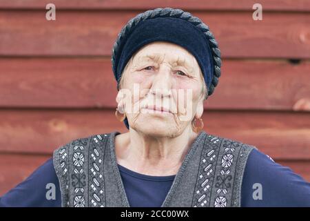 Primo piano ritratto di una donna musulmana anziana in abiti tradizionali guardando la fotocamera. Villaggio Siberiano, Russia Foto Stock