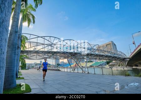 Un uomo scherza sotto l'Helix Bridge che collega l'Esplanade con gli Shoppes a Marina Bay Sands, che si estende su Marina Bay; Singapore Foto Stock