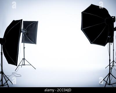 Sfondo bianco vuoto negli interni degli studi di fotografia con configurazione dell'illuminazione. Studio fotografico vuoto con apparecchiature di illuminazione. Foto Stock