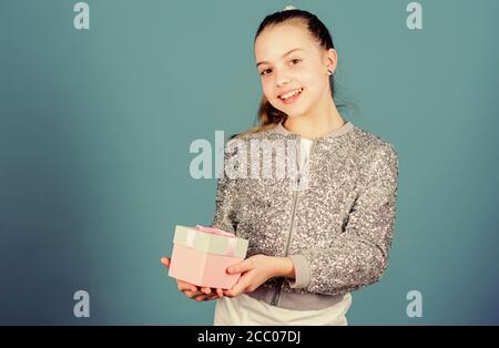 Ragazza con confezione regalo sfondo blu. Venerdì nero. Giornata di shopping. Carino adorabile bambino portano confezione regalo. Regalo a sorpresa box. Desideri per il compleanno. Mondo della felicità. Offerte accade ogni giorno. Il mio prezioso. Foto Stock