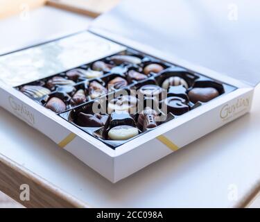 Primo piano di Guylian Belga scatola di cioccolato su un bianco Superficie con luce naturale in un pomeriggio di autunno soleggiato Foto Stock