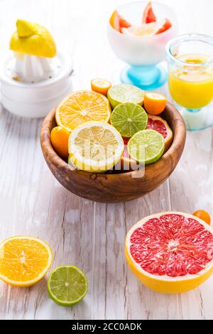 Assortimento di agrumi su sfondo bianco di legno. Preparazione di limonata, tè con ghiaccio o bevanda estiva. Foto Stock