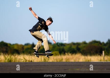 Berlino, Berlino, Germania. 16 agosto 2020. Uno skateboarder esegue un trucco mentre le persone godono il loro tempo libero al parco Tempelhofer Feld sul sito dell'ex aeroporto Tempelhof, nonostante la pandemia mondiale Covid-19 in corso. Credit: Jan Scheunert/ZUMA Wire/Alamy Live News Foto Stock