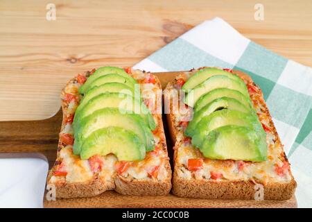 Toast fatti in casa al formaggio con pomodoro e affettati freschi avocado in cima Foto Stock
