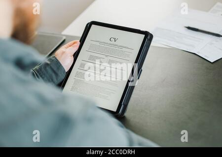 Businessman bearded revisione elettronica cv su tablet. Foto Stock