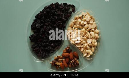 Vista dall'alto di deliziosi noci in contenitori trasparenti in plastica su sfondo verde Foto Stock