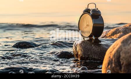 Un orologio che simboleggia l'età d'oro del set fotografico In alto sul Mar Baltico svedese durante il tramonto quando l'estate si trasforma in autunno Foto Stock