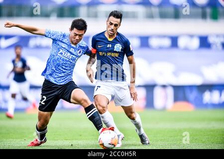 Il calciatore israeliano Eran Zahavi di Guangzhou R&F F.C., a destra, lotta per la palla durante la quinta partita della Super League cinese 2020 (CSL) contro Dalian Professional F.C., città di Dalian, provincia di Liaoning della Cina nordorientale, 16 agosto 2020. Dalian Professional F.C. è stato sconfitto da Guangzhou R&F F.C. con 0-1. Foto Stock