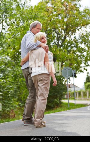 Un paio di anziani cammina lungo un sentiero in città in estate Foto Stock