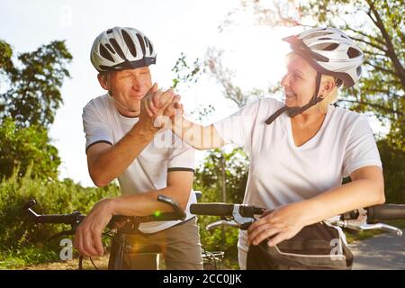 Due ciclisti scuotono le mani per motivarli su una bicicletta tour Foto Stock