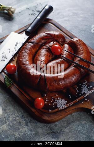 Salsiccia fatta in casa cucinata alla griglia, con pomodori. Foto Stock