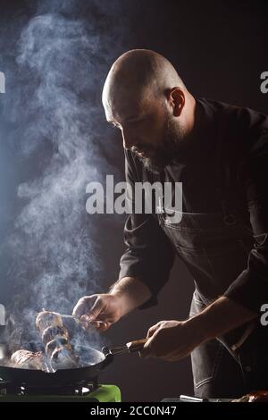 lo chef arrosta i funghi di champagne su uno spiedino Foto Stock