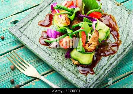 Insalata con carne alla griglia, cavolo, cetriolo e fagioli di asparagi. Carne e verdure arrosto Foto Stock