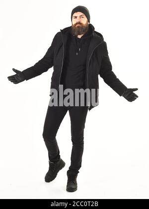 Macho con barba e baffi indossa giacca invernale, guanti, cappello. L'uomo dal volto stretto indossa abiti caldi, isolati su sfondo bianco. Concetto di abbigliamento invernale. Ragazzo in nero e brutale vestito in movimento. Foto Stock