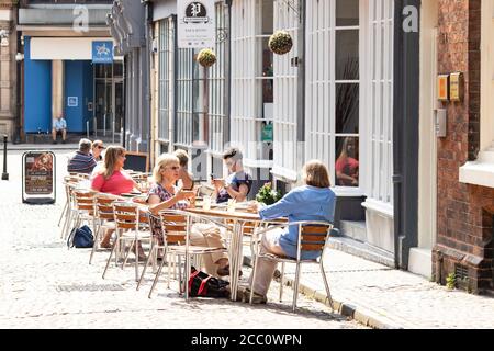 I clienti si sedettero all'esterno sul marciapiede presso il Playwrights Cafe di Hay Lane, nel centro di Coventry. Coventry che diventerà Città della Cultura nel 2021 Foto Stock