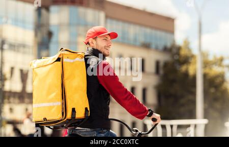 Corriere professionale con zaino in moto che consegna cibo in città Foto Stock