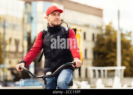 Courier Guy seduto in bicicletta che consegna cibo in zona urbana Foto Stock