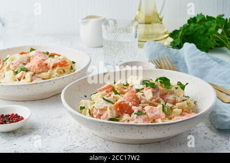 Pasta al salmone, tagliatelle con pesce e salsa cremosa. Cena italiana con pesce Foto Stock