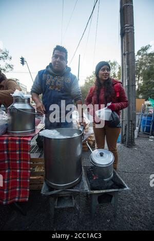 Omar, un fornitore di strada che serve UNA giovane cliente femminile al mattino presto Foto Stock