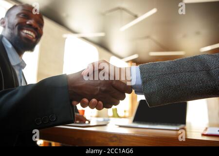 Primo piano di uomini d'affari che scuotono le mani nella sala conferenze, facendo un affare, un accordo di successo o la cooperazione. Concetto di finanza e business, contratti, partnership, comunità e lavoro di squadra. Foto Stock