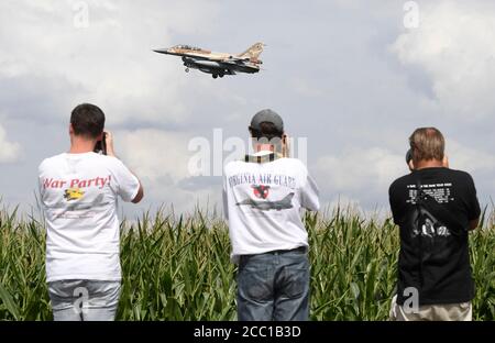 17 agosto 2020, Renania Settentrionale-Vestfalia, Nörvenich: Un bombardiere israeliano F-16 atterra alla base aerea di Nörvenich nel quartiere di Düren, mentre gli uomini con telecamere si trovano accanto a un campo di cornamia e scattano fotografie dell'atterraggio. Tra le altre cose, i jet si trasferono in Germania per esercitazioni militari congiunte con la Bundeswehr. Foto: Roberto Pfeil/dpa Foto Stock