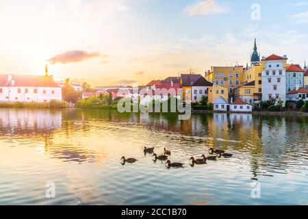 Jindrichuv Hradec paesaggio urbano al tramonto riflesso nel piccolo stagno di Vajgar con gregge di anatre, Repubblica Ceca. Foto Stock