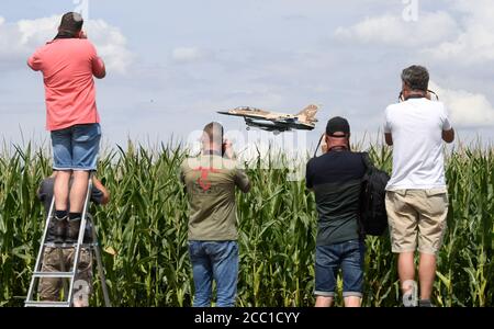 17 agosto 2020, Renania Settentrionale-Vestfalia, Nörvenich: Un bombardiere israeliano F-16 atterra alla base aerea di Nörvenich nel quartiere di Düren, mentre gli uomini con telecamere si trovano accanto a un campo di cornamia e scattano fotografie dell'atterraggio. Tra le altre cose, i jet si trasferono in Germania per esercitazioni militari congiunte con la Bundeswehr. Foto: Roberto Pfeil/dpa Foto Stock