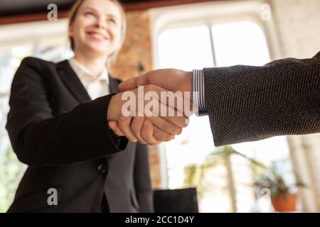 Primo piano di uomini d'affari che scuotono le mani nella sala conferenze, facendo un affare, un accordo di successo o la cooperazione. Concetto di finanza e business, contratti, partnership, comunità e lavoro di squadra. Foto Stock