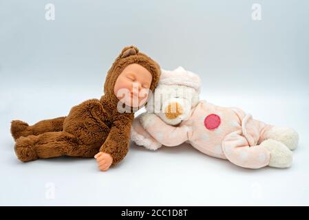 bambola addormentata vestita da un orsacchiotto e da un teddy orso Foto Stock