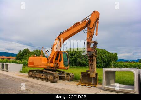 Escavatore cingolato con piattaforma girevole e cingolo continuo caterpillar con cassoni in cemento armato. Sito di sostituzione delle acque reflue, Italia Foto Stock